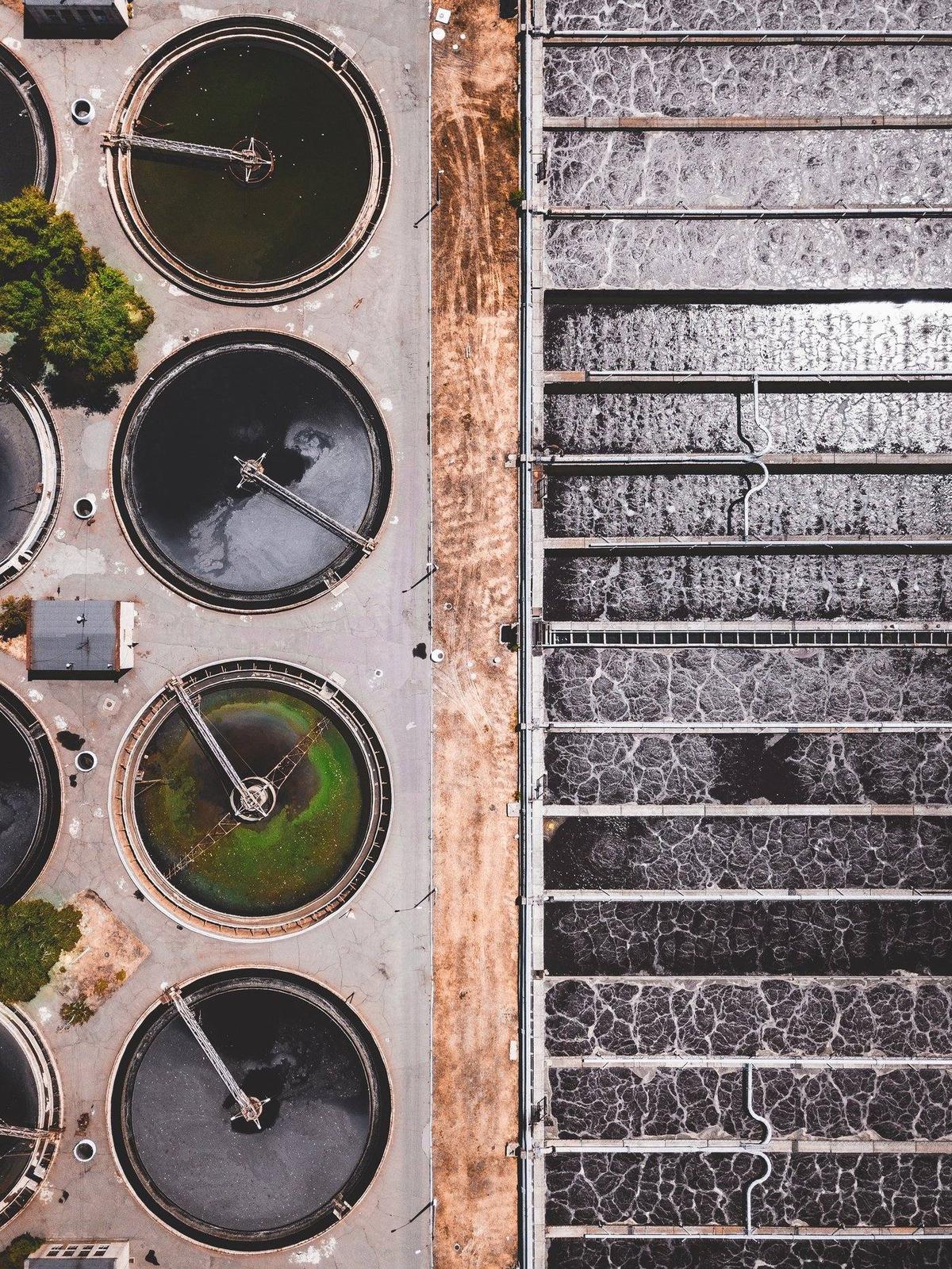 Aerial view of water treatment plant with settling tanks and filtration beds